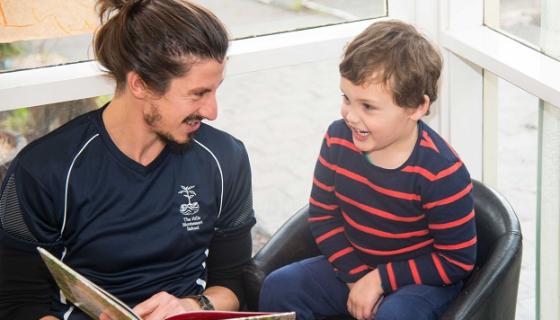 Educator reading to kindergarten boy